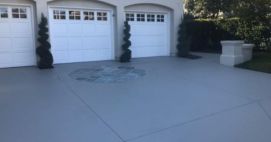 Driveway with solid color concrete stain and decorative medallion by Pacific Concrete